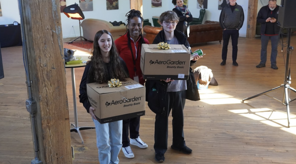 Students holding a box containing an AeroGarden indoor garden
